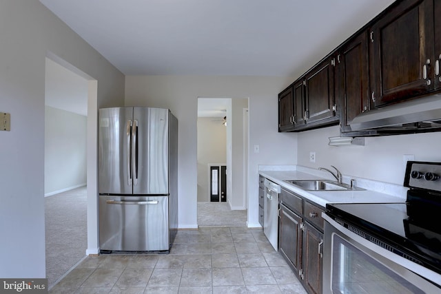 kitchen with a ceiling fan, a sink, appliances with stainless steel finishes, light countertops, and light colored carpet