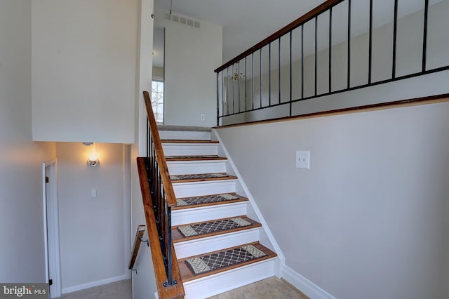 stairway featuring visible vents and baseboards