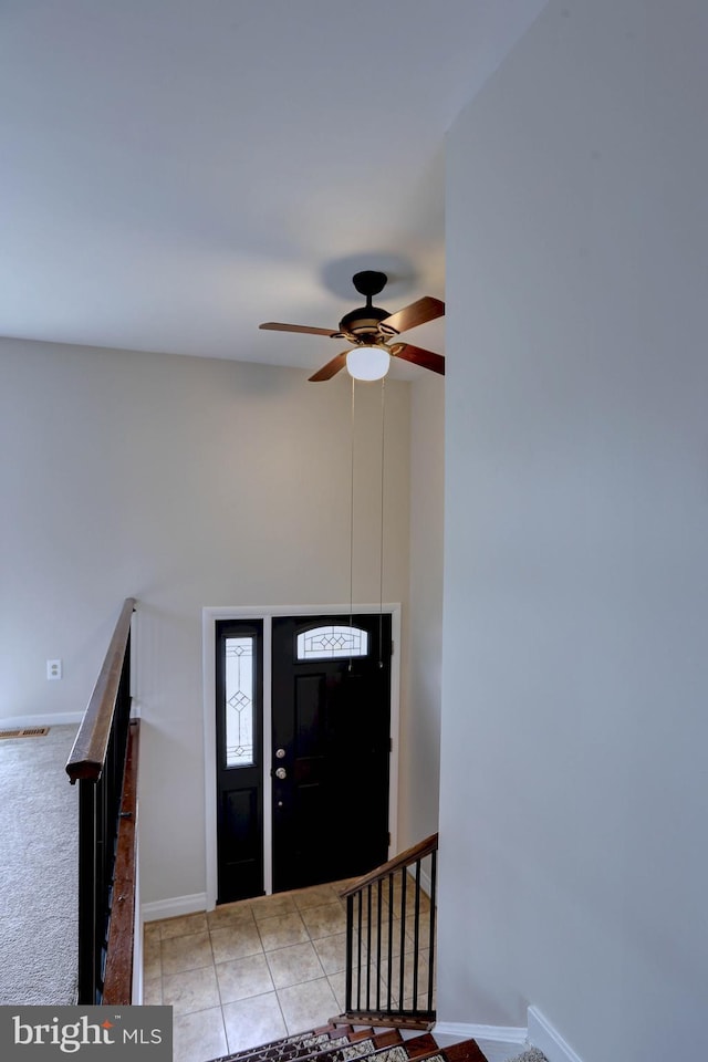 tiled foyer entrance featuring baseboards and a ceiling fan