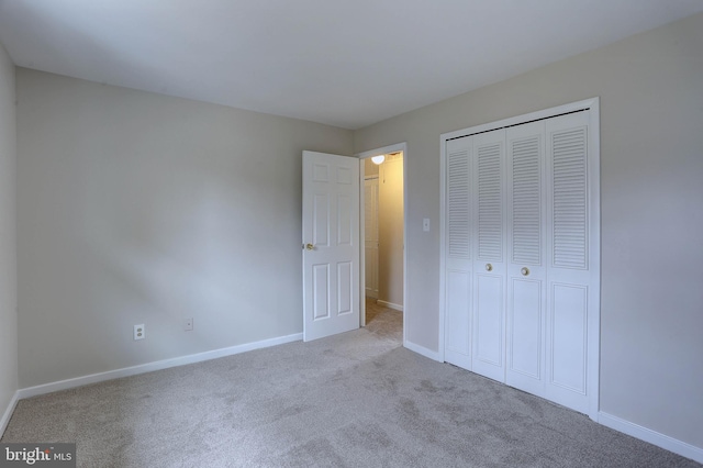 unfurnished bedroom featuring a closet, baseboards, and carpet floors