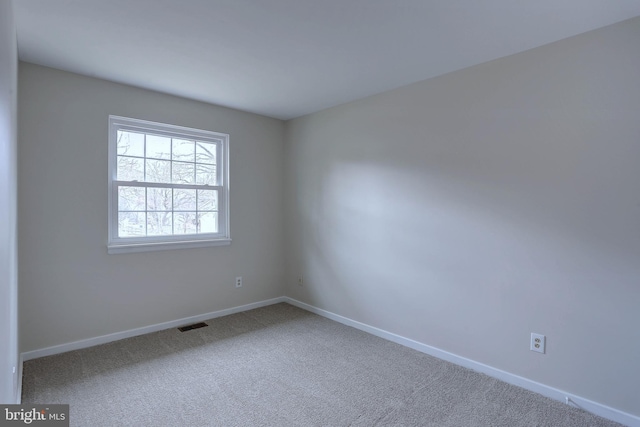 unfurnished room with visible vents, baseboards, and carpet floors