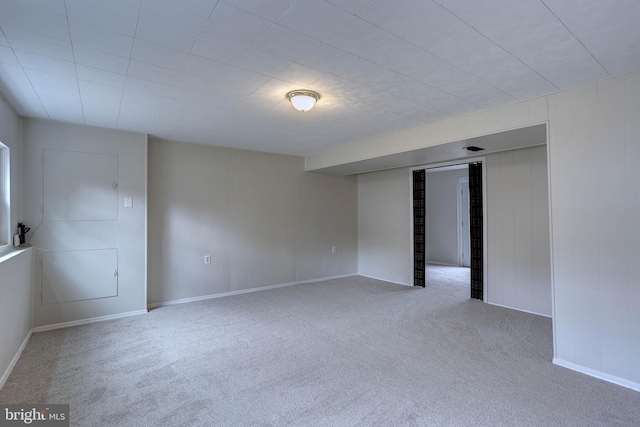 carpeted spare room featuring baseboards