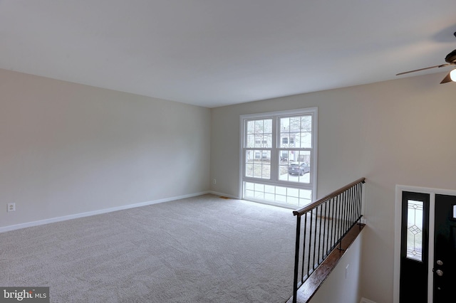 interior space featuring baseboards, ceiling fan, and carpet flooring