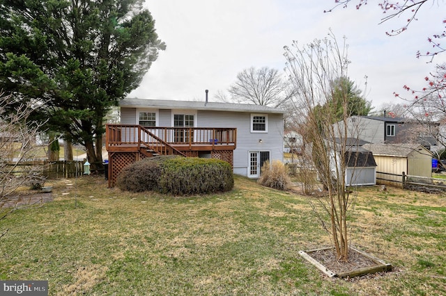 rear view of property with a wooden deck, an outbuilding, a yard, and fence