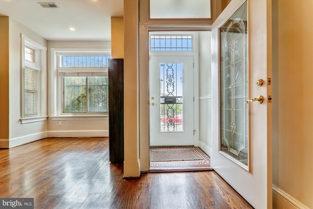 foyer featuring visible vents, baseboards, and wood finished floors