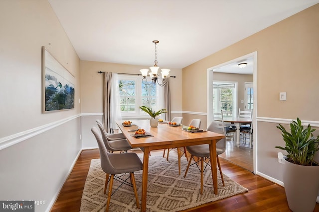 dining area with a notable chandelier, wood finished floors, and baseboards