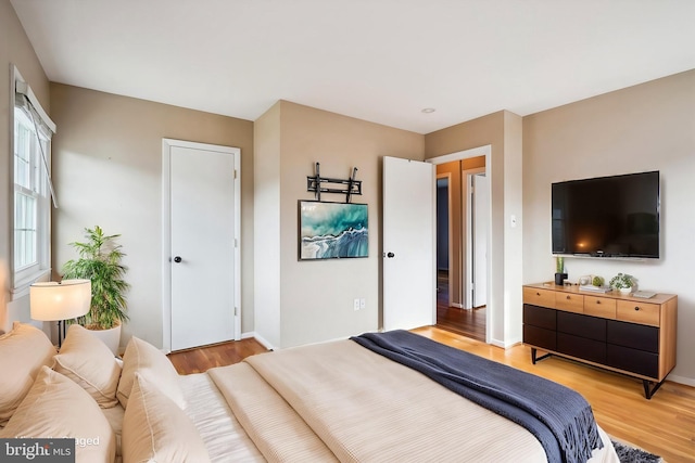 bedroom featuring light wood-type flooring and baseboards