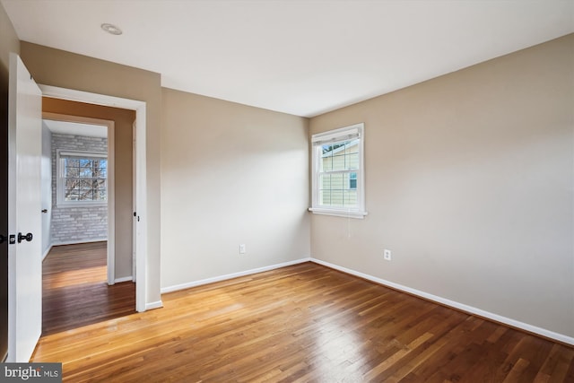 spare room with light wood-style flooring, a healthy amount of sunlight, and baseboards