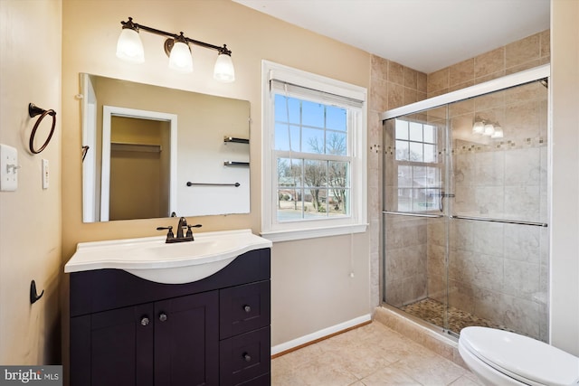 bathroom featuring vanity, baseboards, tile patterned flooring, a shower stall, and toilet