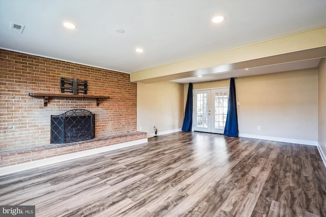 unfurnished living room with french doors, baseboards, wood finished floors, and a fireplace