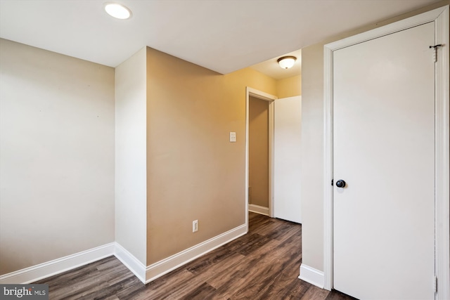 hall featuring baseboards and dark wood-style flooring