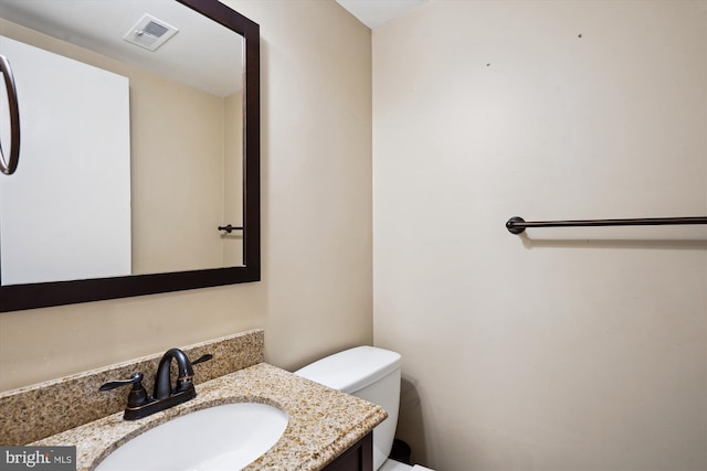 bathroom with visible vents, toilet, and vanity