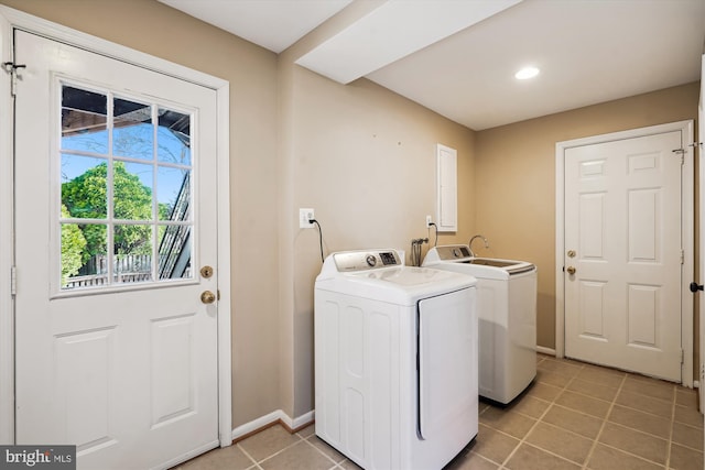 washroom featuring laundry area, light tile patterned floors, baseboards, and washing machine and clothes dryer