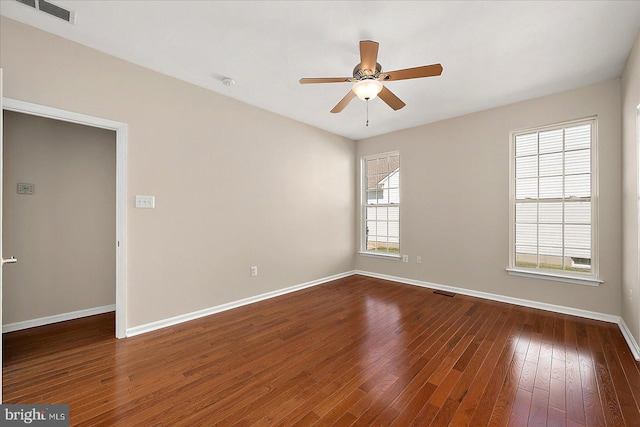 unfurnished room featuring ceiling fan, visible vents, baseboards, and dark wood finished floors
