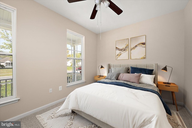 bedroom with baseboards, multiple windows, carpet flooring, and a ceiling fan