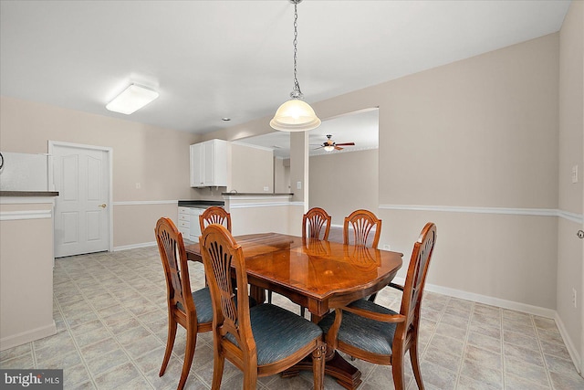 dining area with ceiling fan, light floors, and baseboards