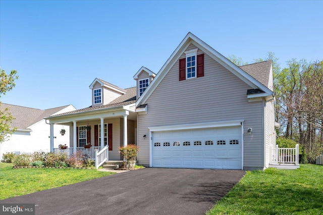 view of front of house featuring a front lawn, a shingled roof, covered porch, and driveway