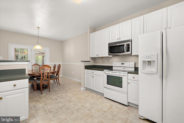 kitchen with white cabinetry, dark countertops, white appliances, and light floors