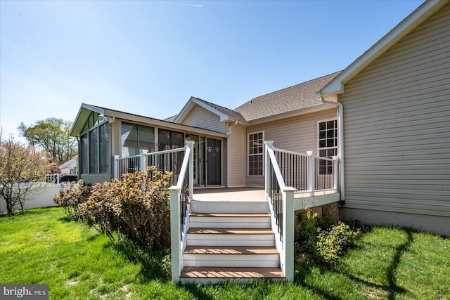 back of property with a sunroom, a yard, and stairs