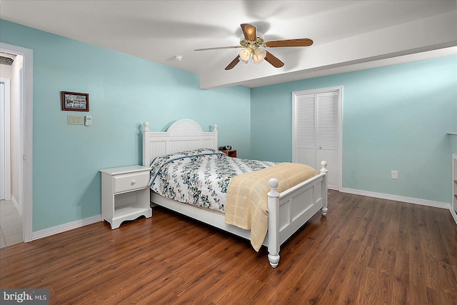 bedroom with a closet, dark wood-style flooring, baseboards, and a ceiling fan