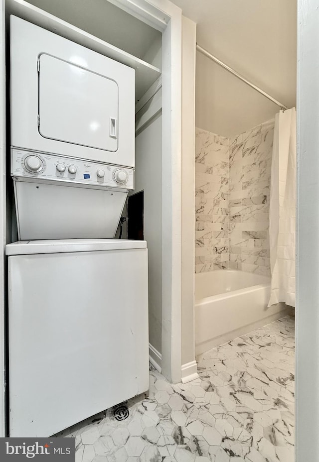 clothes washing area with stacked washing maching and dryer, laundry area, and marble finish floor