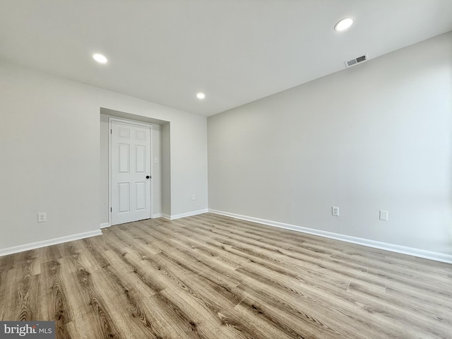 spare room featuring light wood finished floors, recessed lighting, visible vents, and baseboards