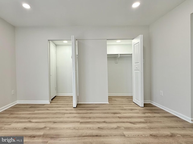 unfurnished bedroom featuring recessed lighting, a closet, baseboards, and wood finished floors