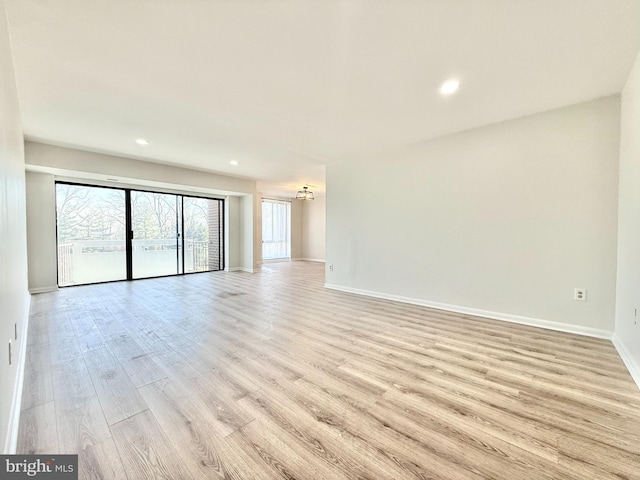 unfurnished living room with recessed lighting, baseboards, and light wood finished floors