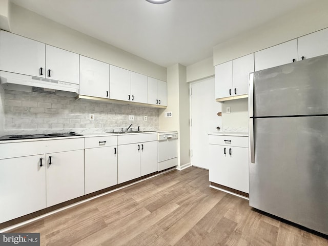 kitchen with freestanding refrigerator, white dishwasher, stovetop, light wood-type flooring, and under cabinet range hood