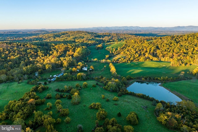 aerial view with a wooded view and a water and mountain view