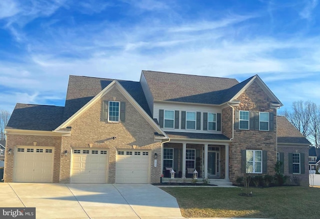 view of front of property featuring brick siding, a shingled roof, concrete driveway, stone siding, and a front lawn