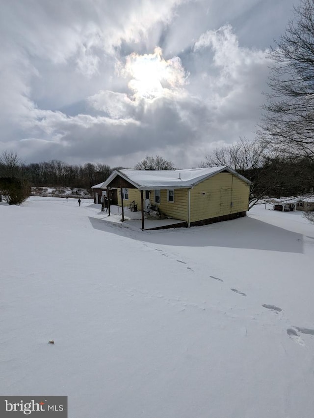 view of snow covered back of property