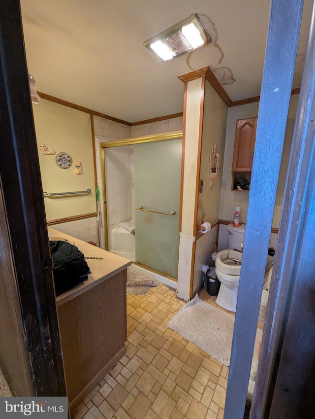 bathroom featuring brick patterned floor, a stall shower, crown molding, and toilet