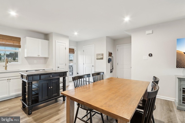 dining room with light wood-style flooring, baseboards, and recessed lighting