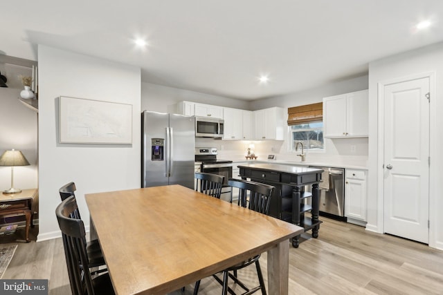 dining room with light wood-style flooring and recessed lighting