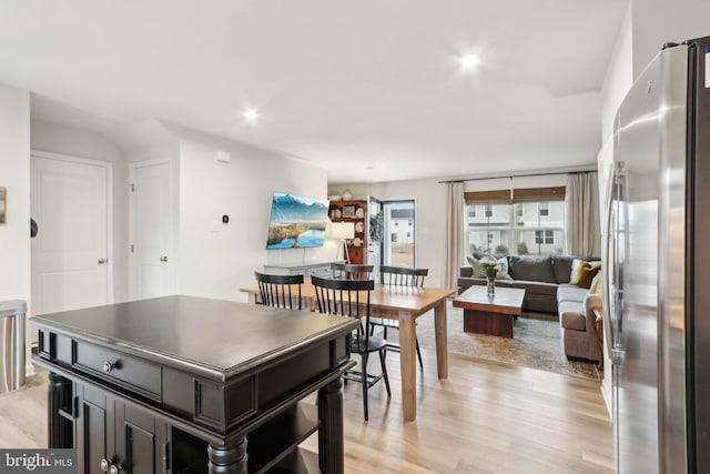 kitchen featuring open floor plan, freestanding refrigerator, dark cabinetry, light wood-type flooring, and recessed lighting