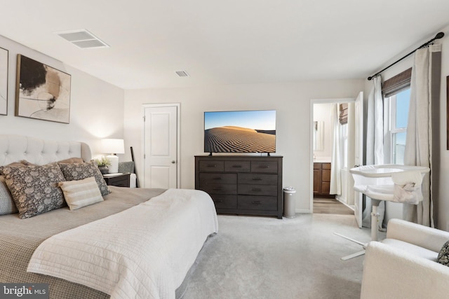 carpeted bedroom featuring visible vents