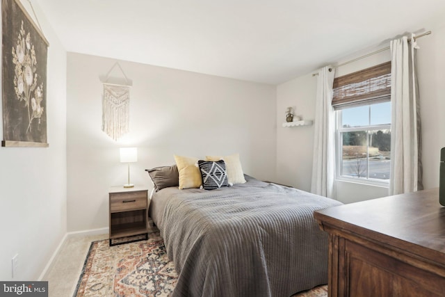 bedroom featuring baseboards and light colored carpet