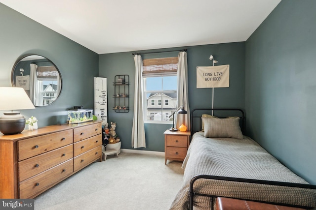 bedroom with light carpet and baseboards