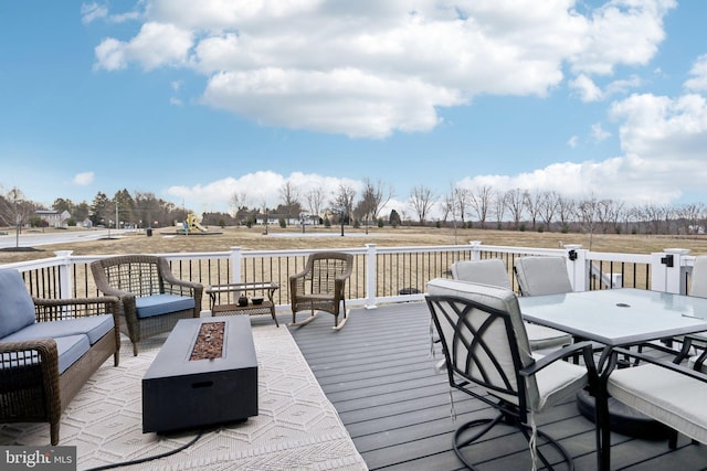 wooden terrace with outdoor dining area, a playground, and an outdoor living space with a fire pit