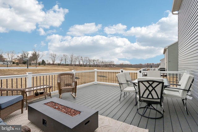 wooden terrace with an outdoor fire pit and outdoor dining space