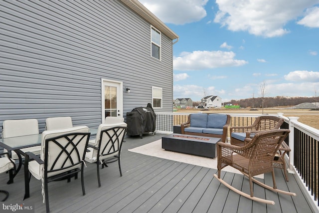 wooden deck featuring an outdoor living space with a fire pit, outdoor dining space, and a grill