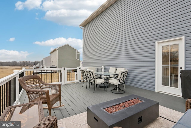 wooden deck with an outdoor fire pit and outdoor dining area