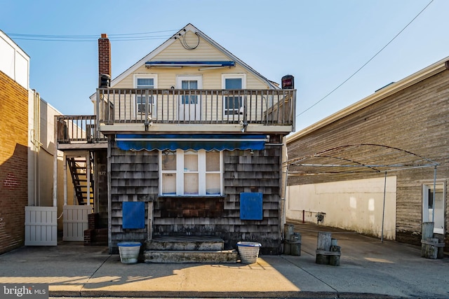 back of house featuring stairway