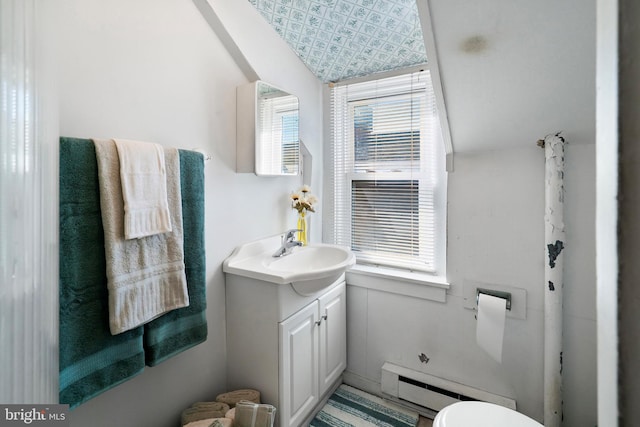 bathroom featuring baseboard heating, a healthy amount of sunlight, vanity, and toilet