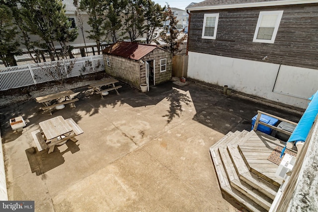 view of patio / terrace with a storage shed, an outdoor structure, and fence