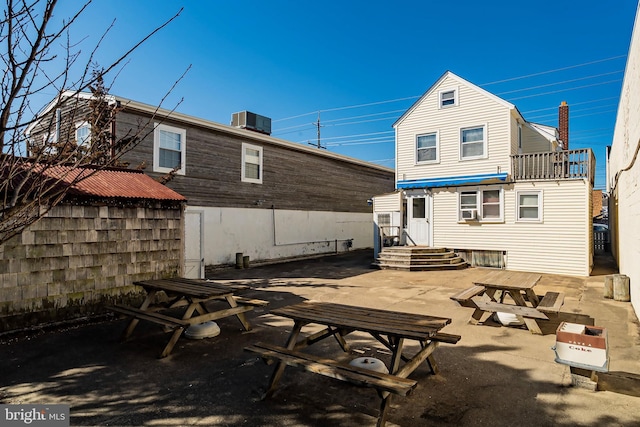 rear view of property with central AC unit and a patio area