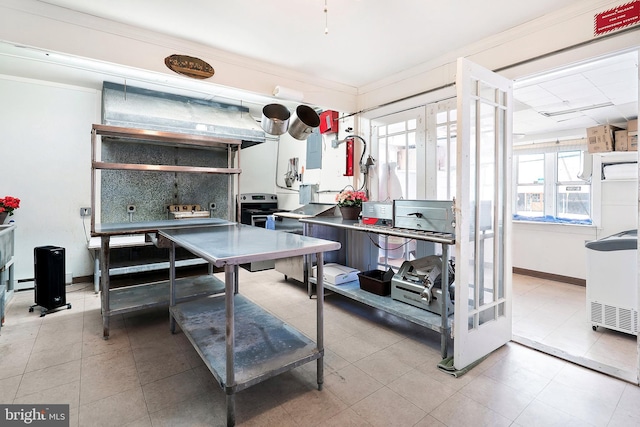 kitchen featuring light tile patterned floors, baseboards, and ornamental molding