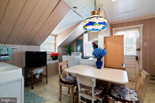 dining area with a wealth of natural light, wooden walls, independent washer and dryer, and vaulted ceiling