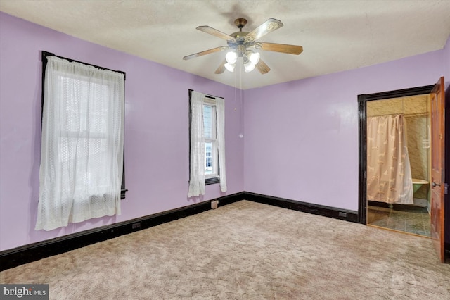 unfurnished room featuring a ceiling fan, carpet, a textured ceiling, and baseboards